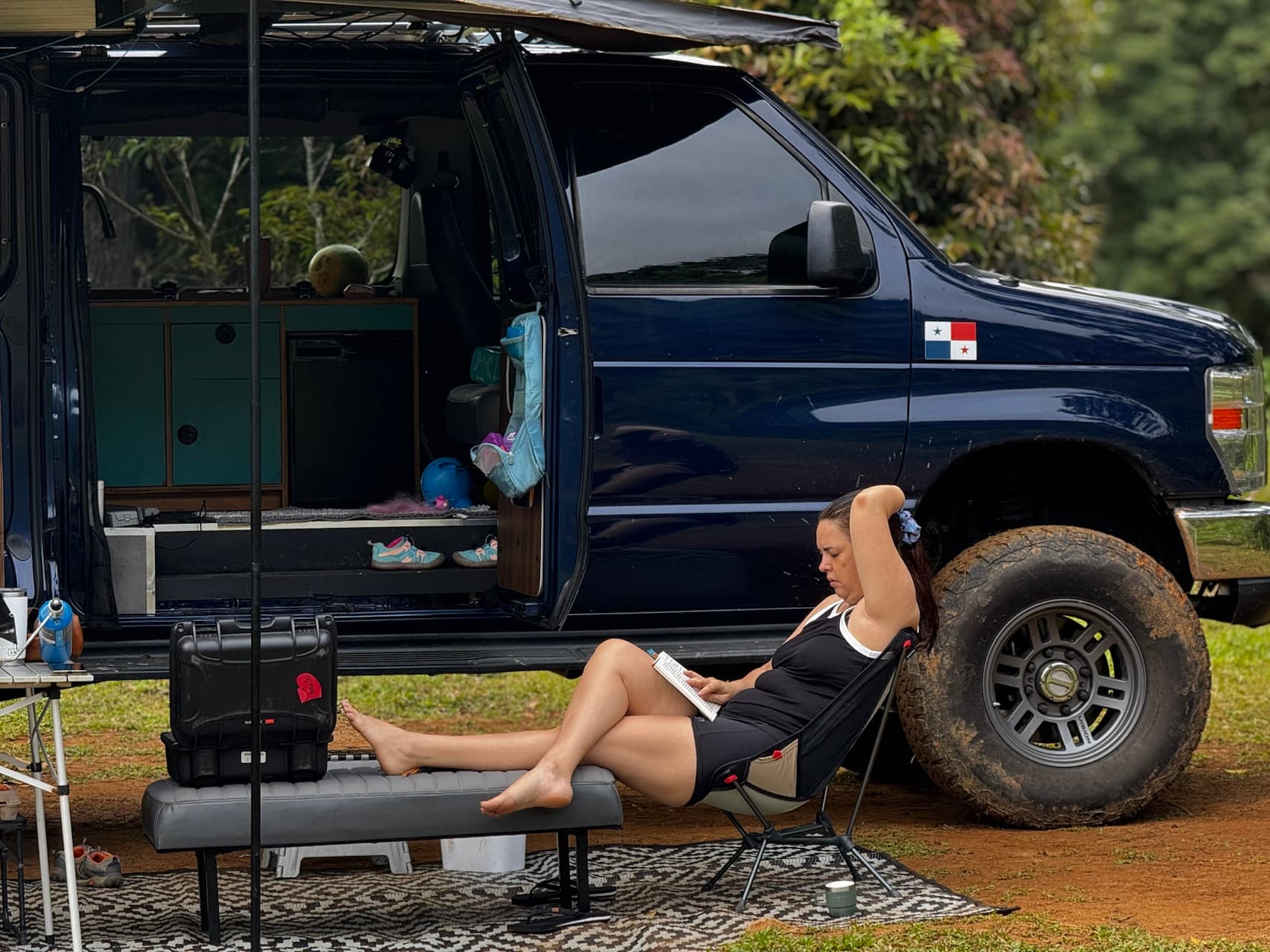 Camper en campamento con toldo desplegado y cocina exterior