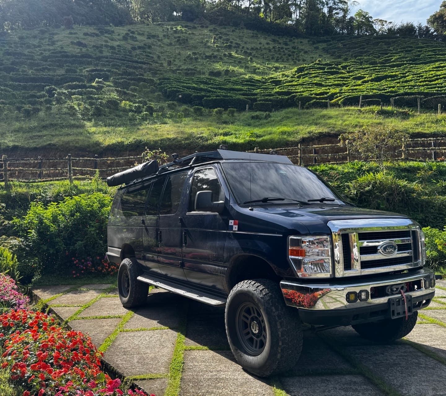 Camper convertida estacionada en montañas verdes con bandera de Panamá