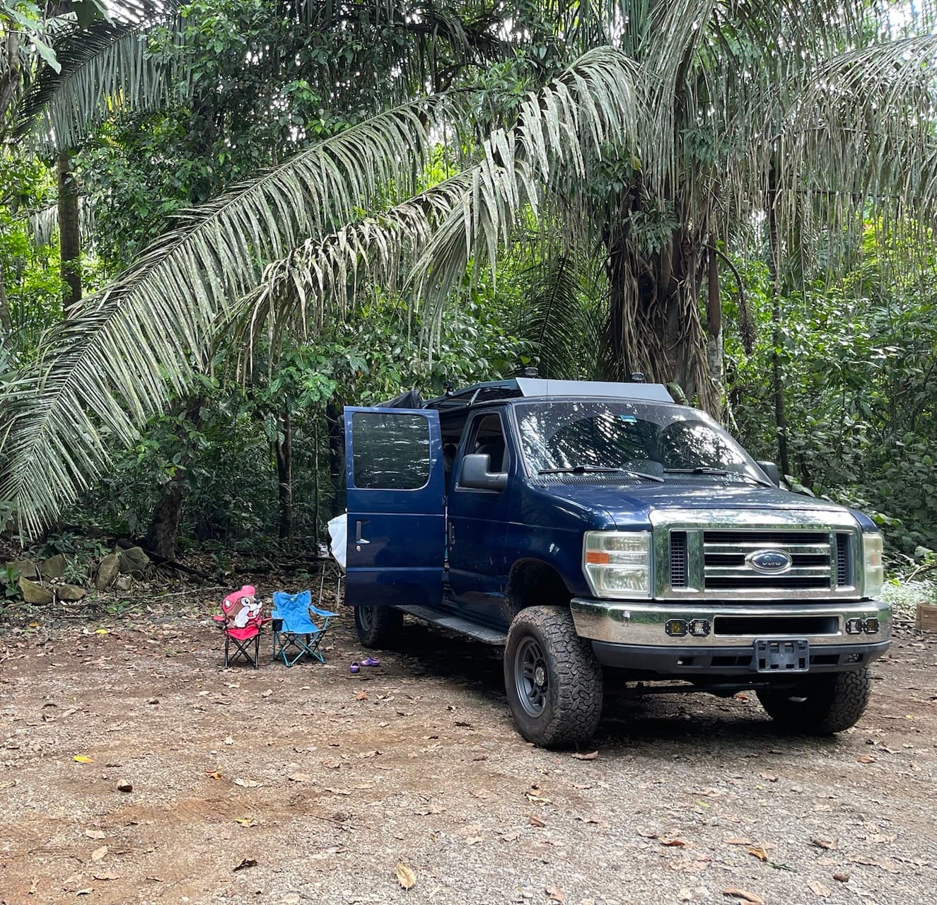 Van convertida con portaequipajes en un claro selvático